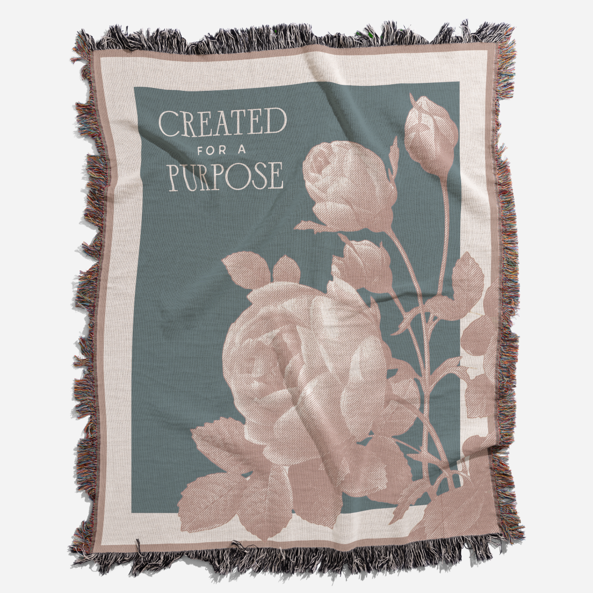 Blanket with floral design and 'Created for a Purpose' text on a teal background