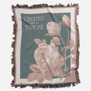 Blanket with floral design and 'Created for a Purpose' text on a teal background