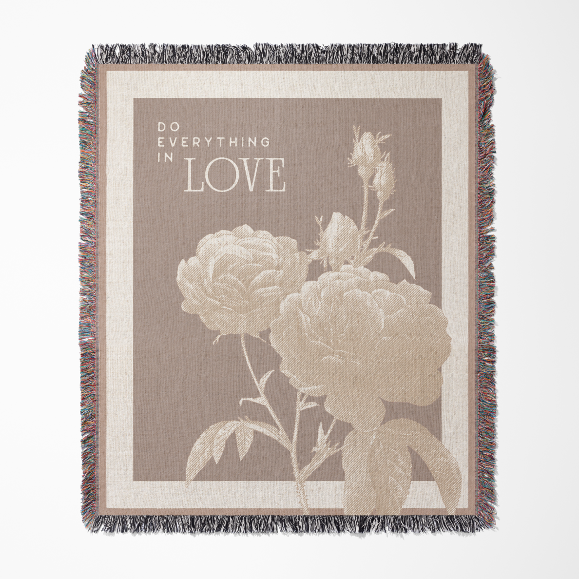 Blanket with floral design and 'Do Everything in Love' text on a beige background