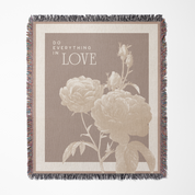 Blanket with floral design and 'Do Everything in Love' text on a beige background