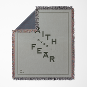Blanket with 'Faith Over Fear' text on a gray background