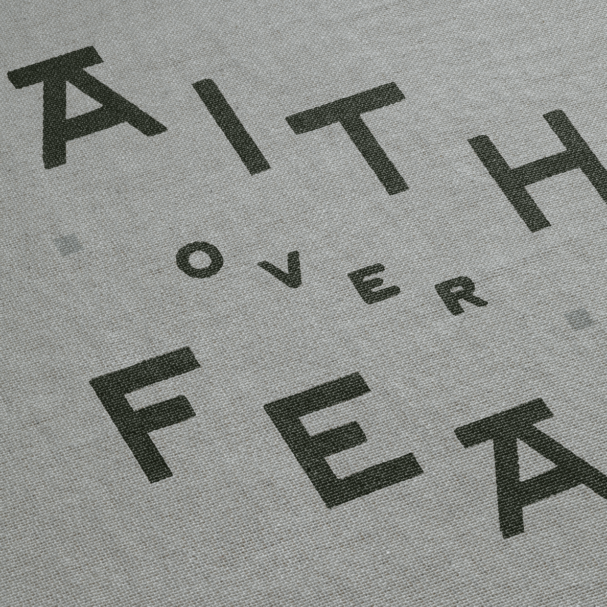 Gray fabric with black text 'FAITH OVER FEAR' printed on it