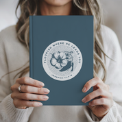 Person holding a blue book with a floral design and text