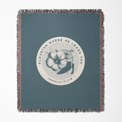Blue throw blanket with floral design and text on a white background