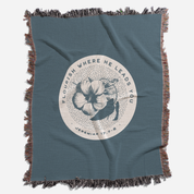 Blue throw blanket with floral design and text on a white background