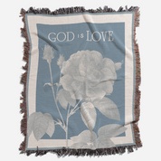 Blanket with floral design and 'God is Love' text on a blue background