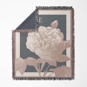 Floral patterned throw blanket with a large pink flower on a dark background