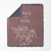 Blanket with floral design and text 'RACE LIVES HERE' on a white background