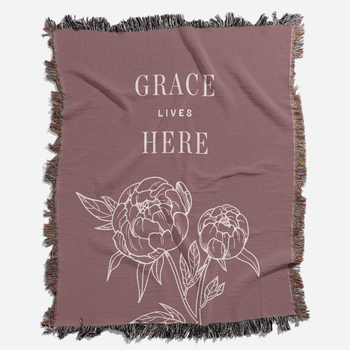 Brown blanket with floral design and 'Grace Lives Here' text on a white background