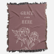 Brown blanket with floral design and 'Grace Lives Here' text on a white background