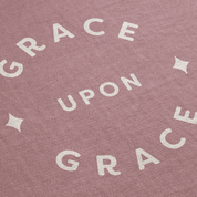Text pattern with 'GRACE UPON GRACE' on a pink background