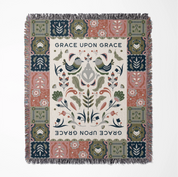Faith-inspired woven blanket featuring the phrase “Grace Upon Grace” with colorful fringed edges, perfect for Christian home decor and gifts.