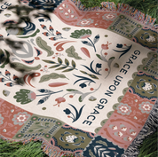 Faith-inspired woven blanket featuring the phrase “Grace Upon Grace” with colorful fringed edges, perfect for Christian home decor and gifts.