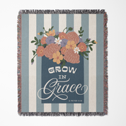 Blanket with floral design and 'Grow in Grace' text on a striped background