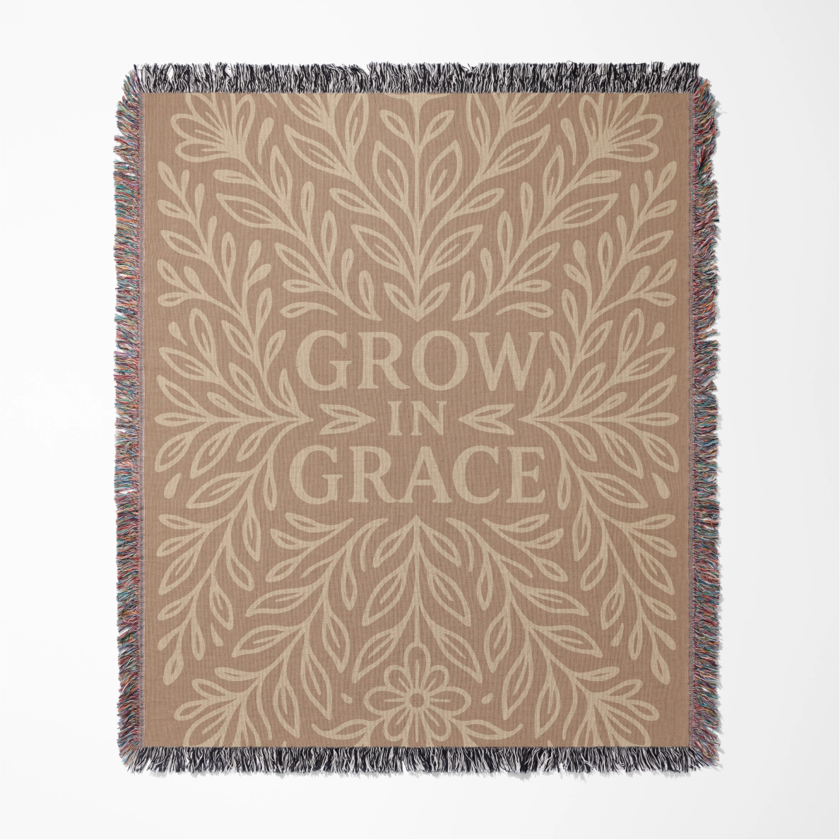 Neutral-toned woven blanket with the phrase "Grow in Grace" surrounded by elegant floral design; made from 100% cotton with fringe, perfect Christian gift or decor.