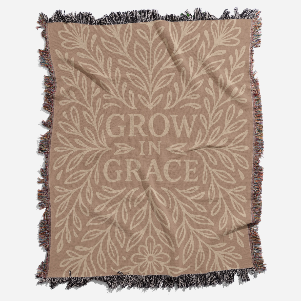 Neutral-toned woven blanket with the phrase "Grow in Grace" surrounded by elegant floral design; made from 100% cotton with fringe, perfect Christian gift or decor.