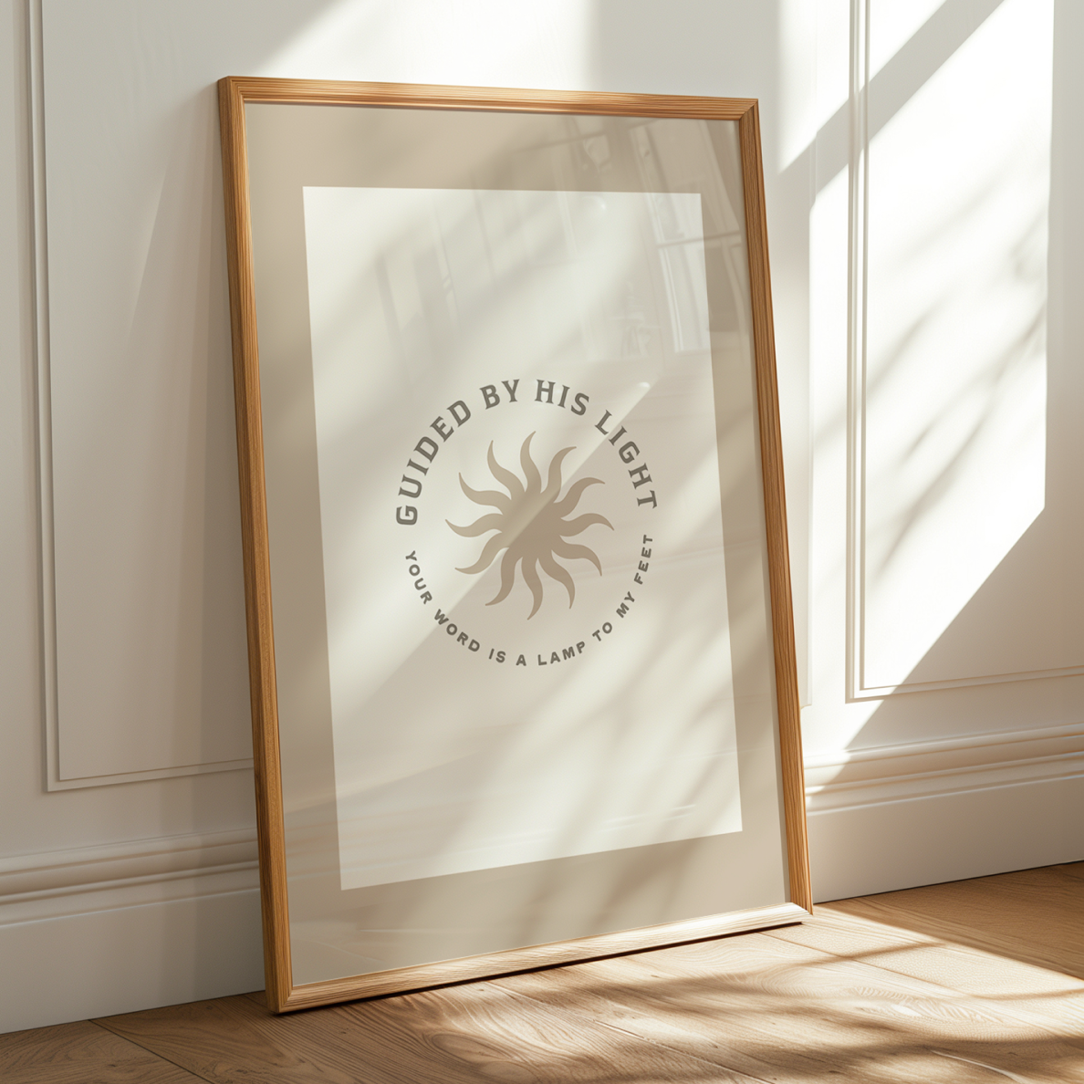 Framed artwork with text and sun design on a wall with sunlight casting shadows.