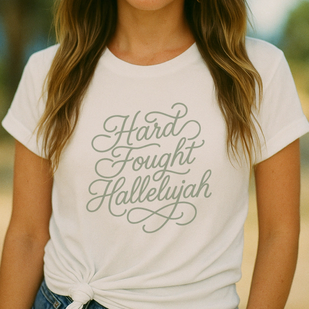 Unisex Christian t-shirt with hand-lettered “Hard Fought Hallelujah” text; soft cotton faith-based shirt for worship, encouragement, and praise through trials.