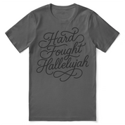 Christian t-shirt with hand-lettered “Hard Fought Hallelujah” design; unisex cotton tee for faith, perseverance, and praise through hardship.