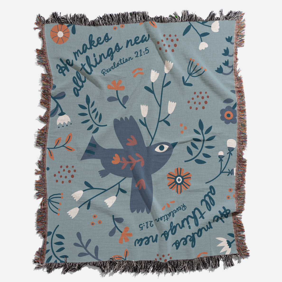 Studio photography of blanket with He makes all things new. 