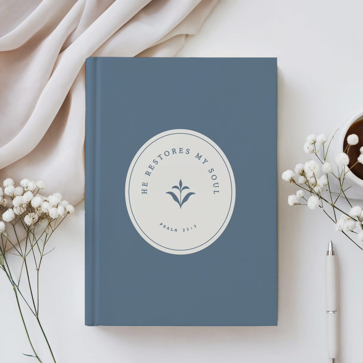 Blue notebook with a circular design and text on a light background with flowers