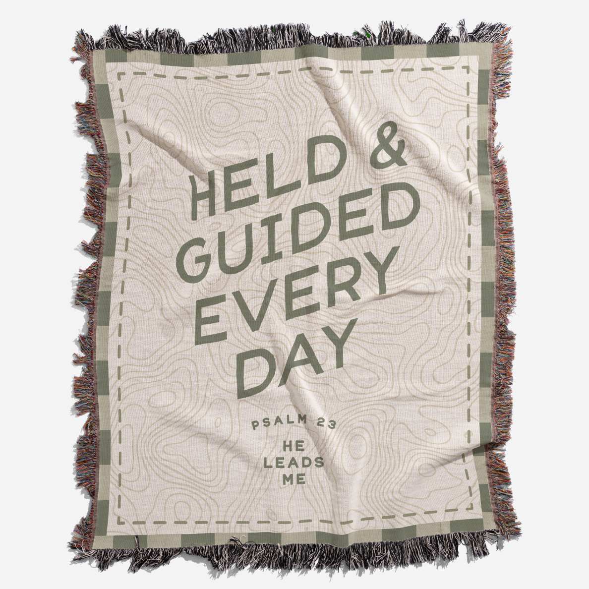 Blanket with text 'HELD & GUIDED EVERY DAY' and 'PSALM 23 HE LEADS ME' on a white background