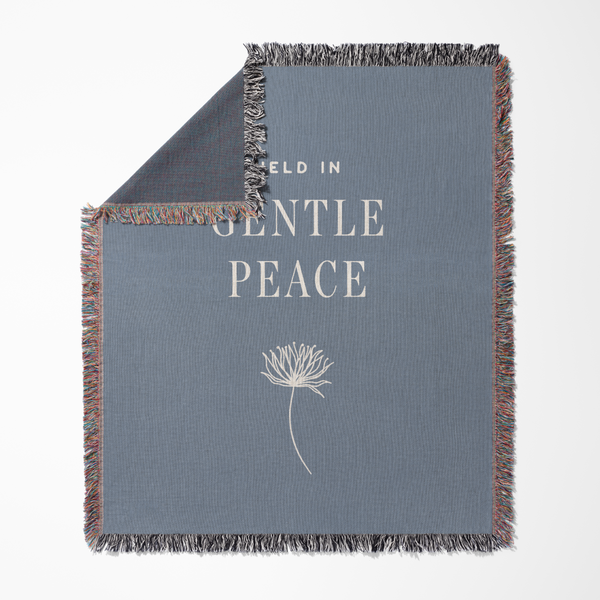 Gray blanket with 'Field in Gentle Peace' text and dandelion graphic on a white background