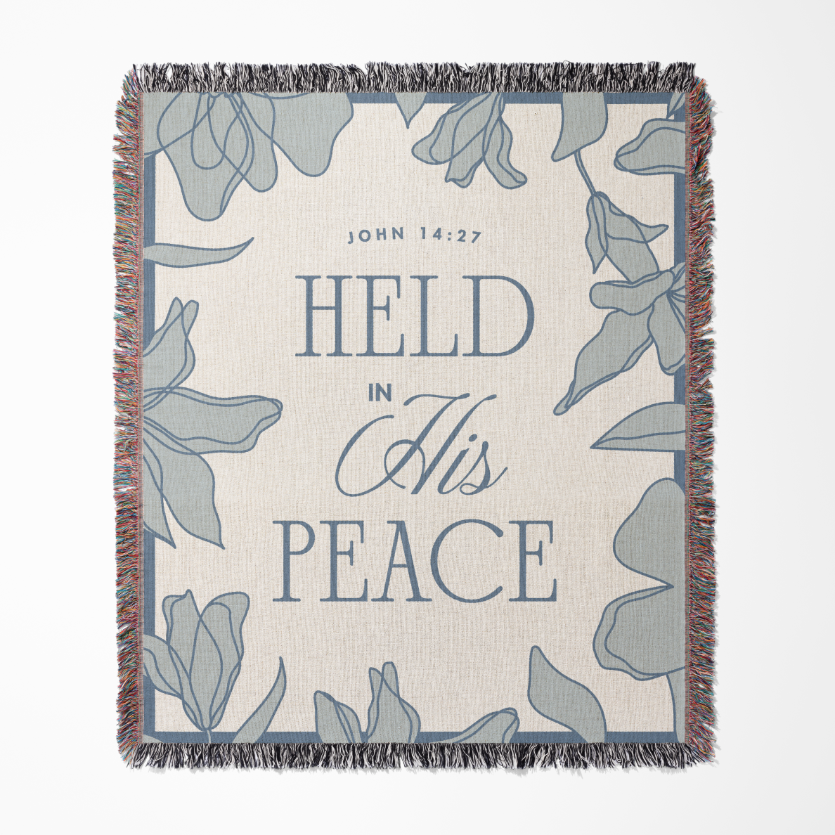 Blanket with floral design and text 'HELD IN HIS PEACE' and 'John 14:27' on a white background