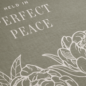 Text 'HELD IN PERFECT PEACE' with floral design on a gray background