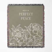 Floral patterned blanket with 'Held in Perfect Peace' text on a plain background