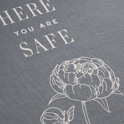 Floral design with 'Here you are safe' text on a gray background