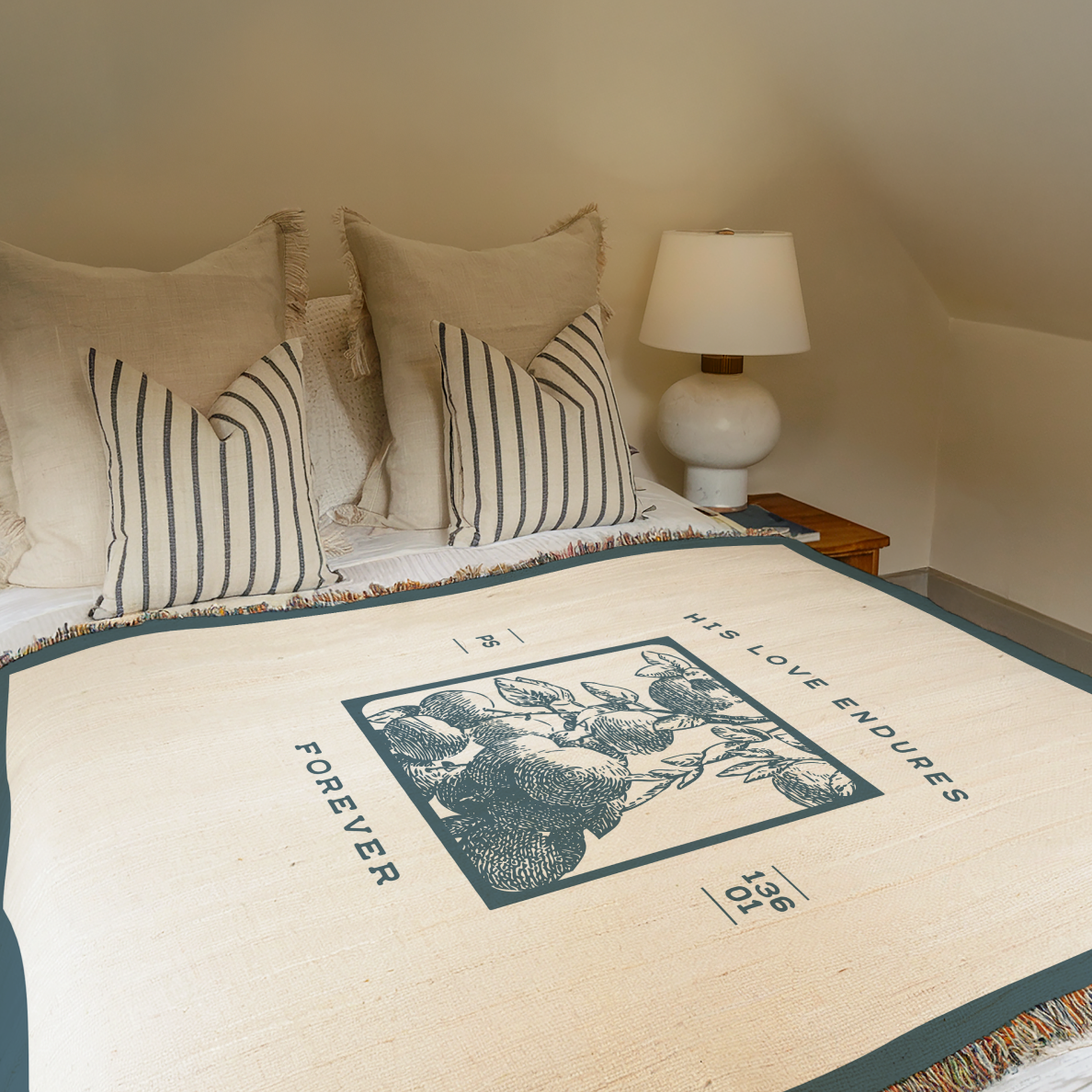 Bed with decorative throw blanket featuring a floral design and text, in a bedroom setting.