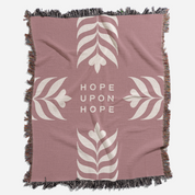 Pink blanket with white leaf patterns and 'Hope Upon Hope' text on a white background