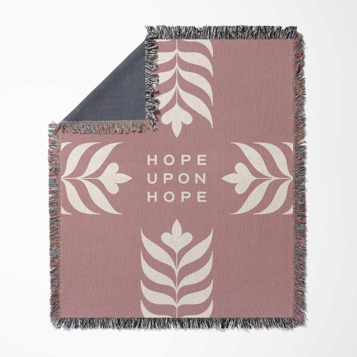 Blanket with floral patterns and 'Hope Upon Hope' text on a pink background