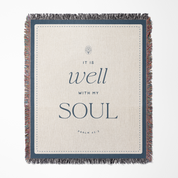 Blanket with 'It is well with my soul' text and fringed edges on a white background
