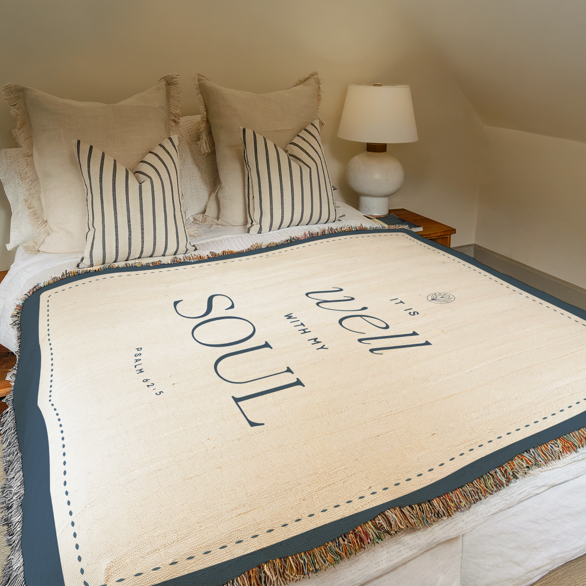Bed with decorative throw blanket featuring text in a bedroom setting