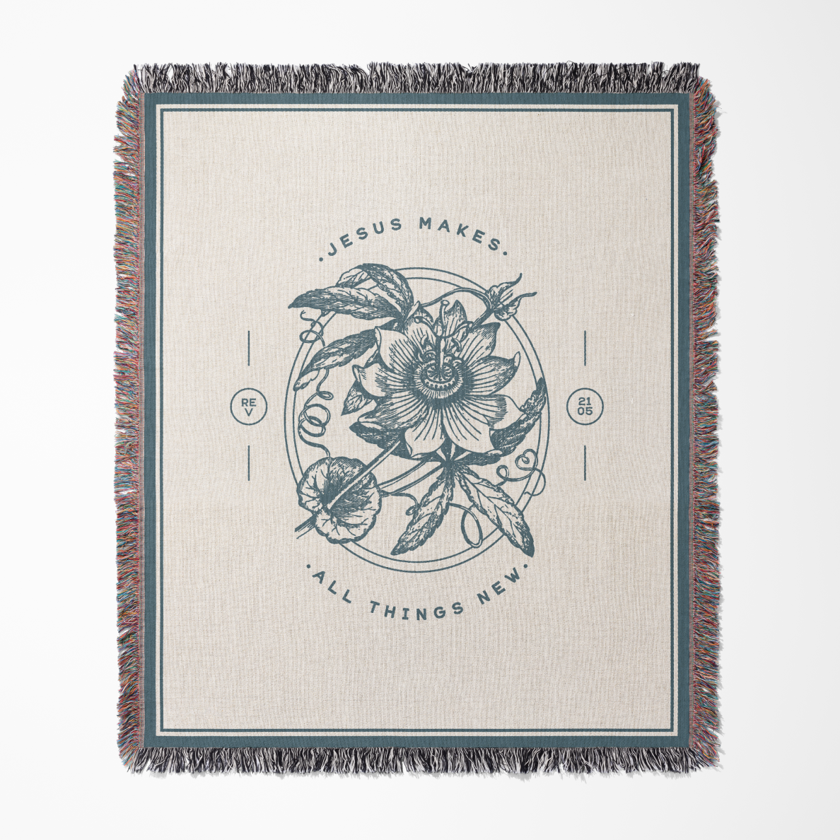 Blanket with floral design and text 'Jesus makes all things new' on a beige background