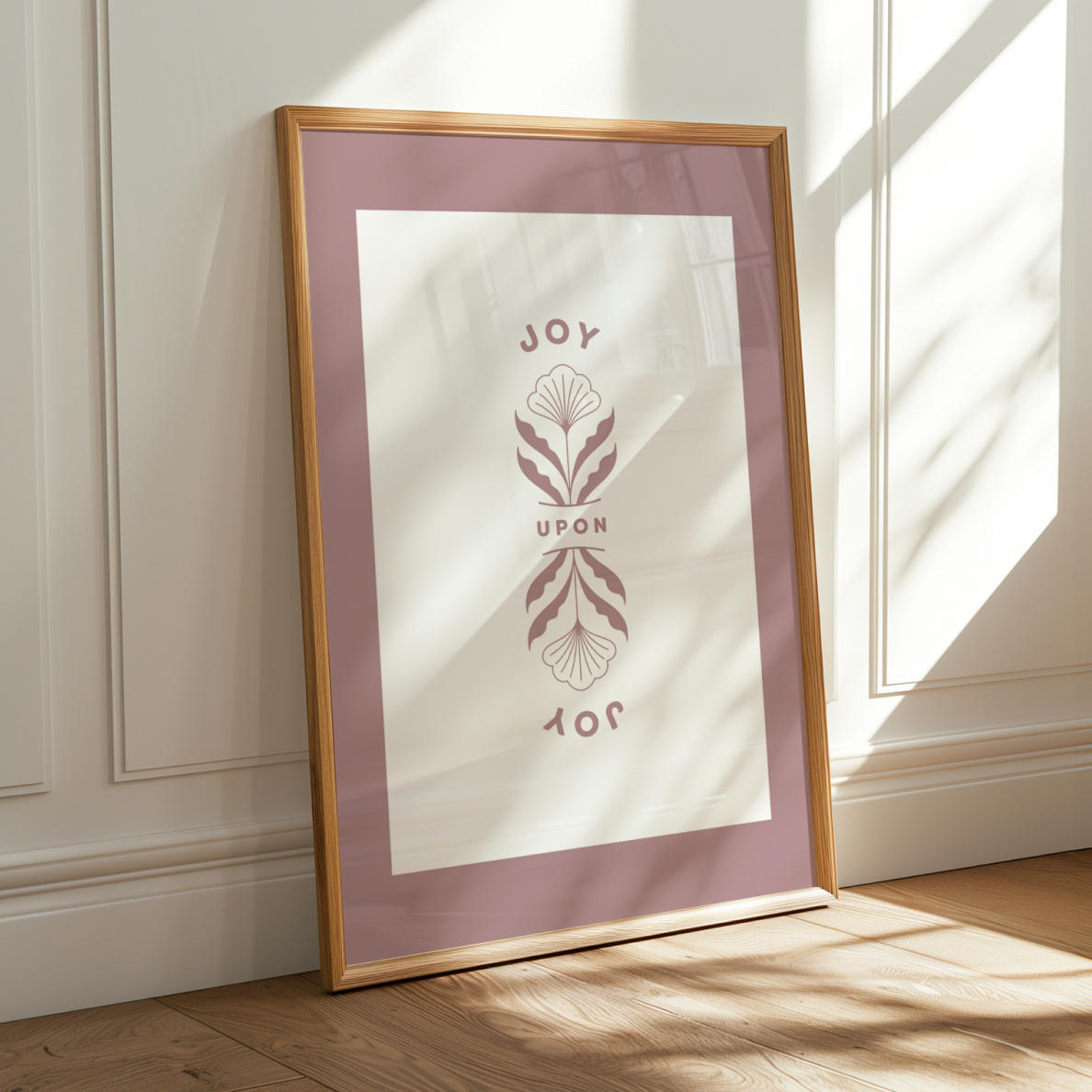 Framed artwork with 'JOY UPON' text and design on a wall.