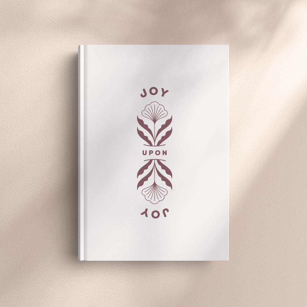 White book with decorative cover design on a beige background