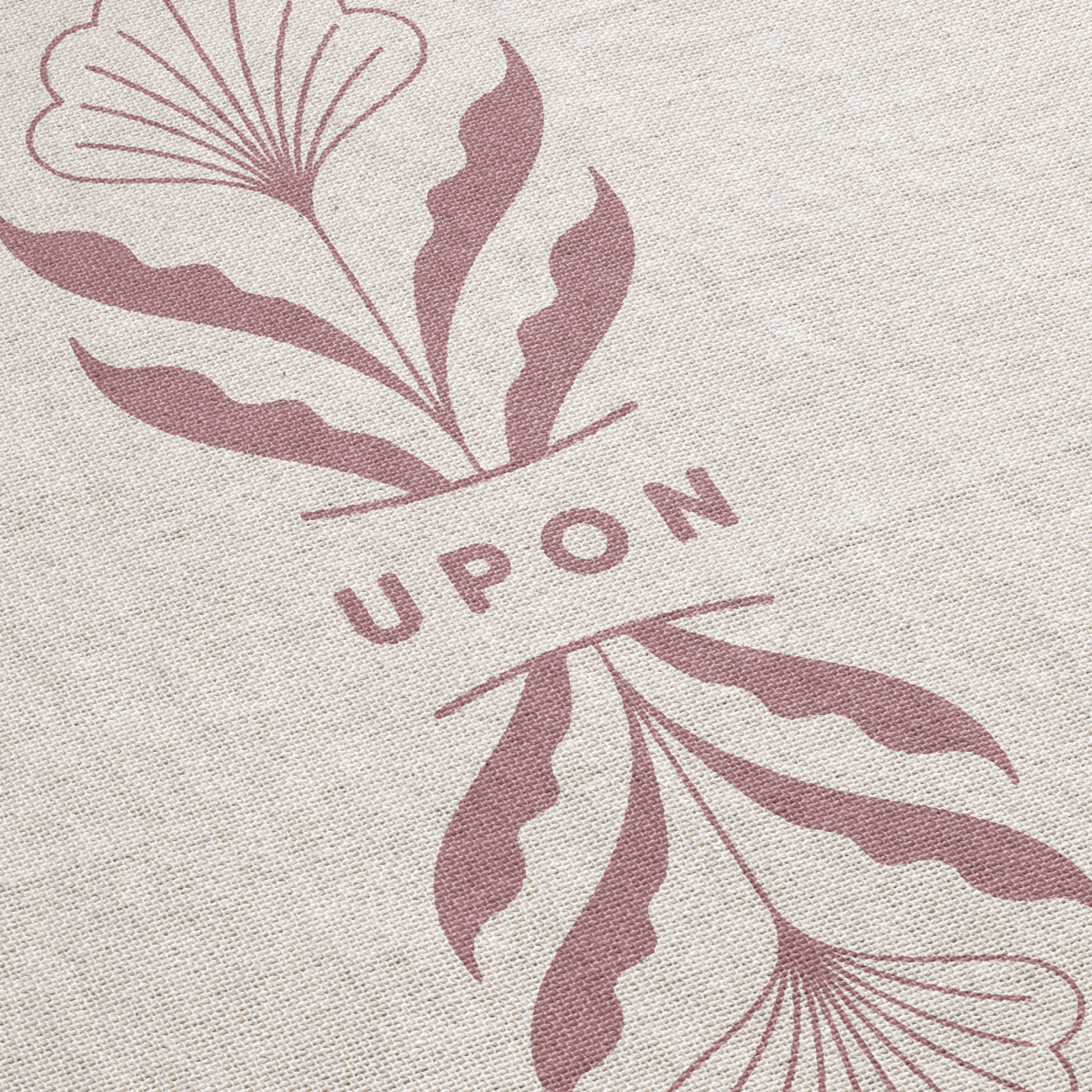 Textile with leaf patterns and the word 'UPON' on a beige background