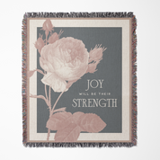 Decorative throw blanket with floral design and motivational quote on a gray background