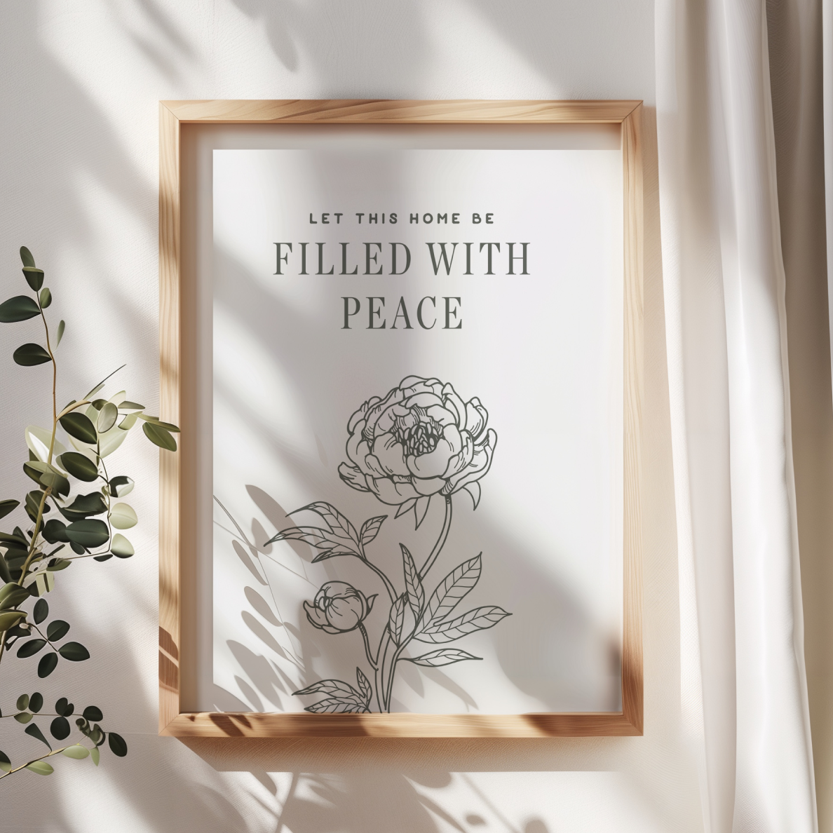 Framed artwork with floral design and text 'Let this home be filled with peace' on a light background.