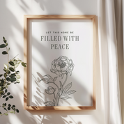 Framed artwork with floral design and text 'Let this home be filled with peace' on a light background.