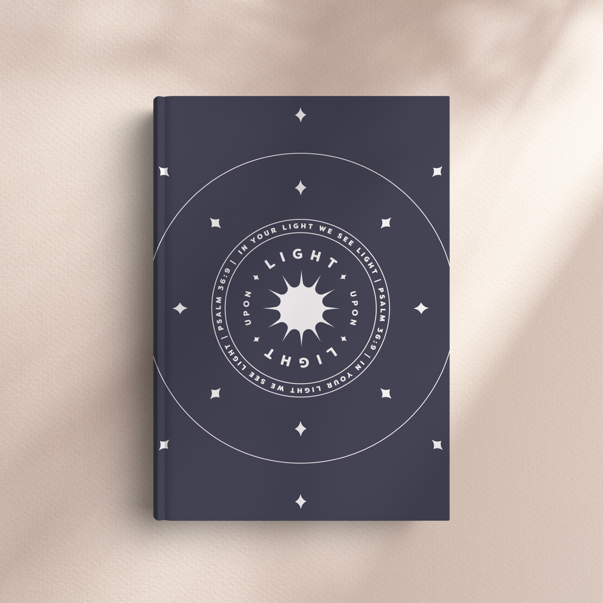 Navy blue book with white circular design and text on a beige background