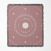 Pink throw blanket with circular design and text on a white background