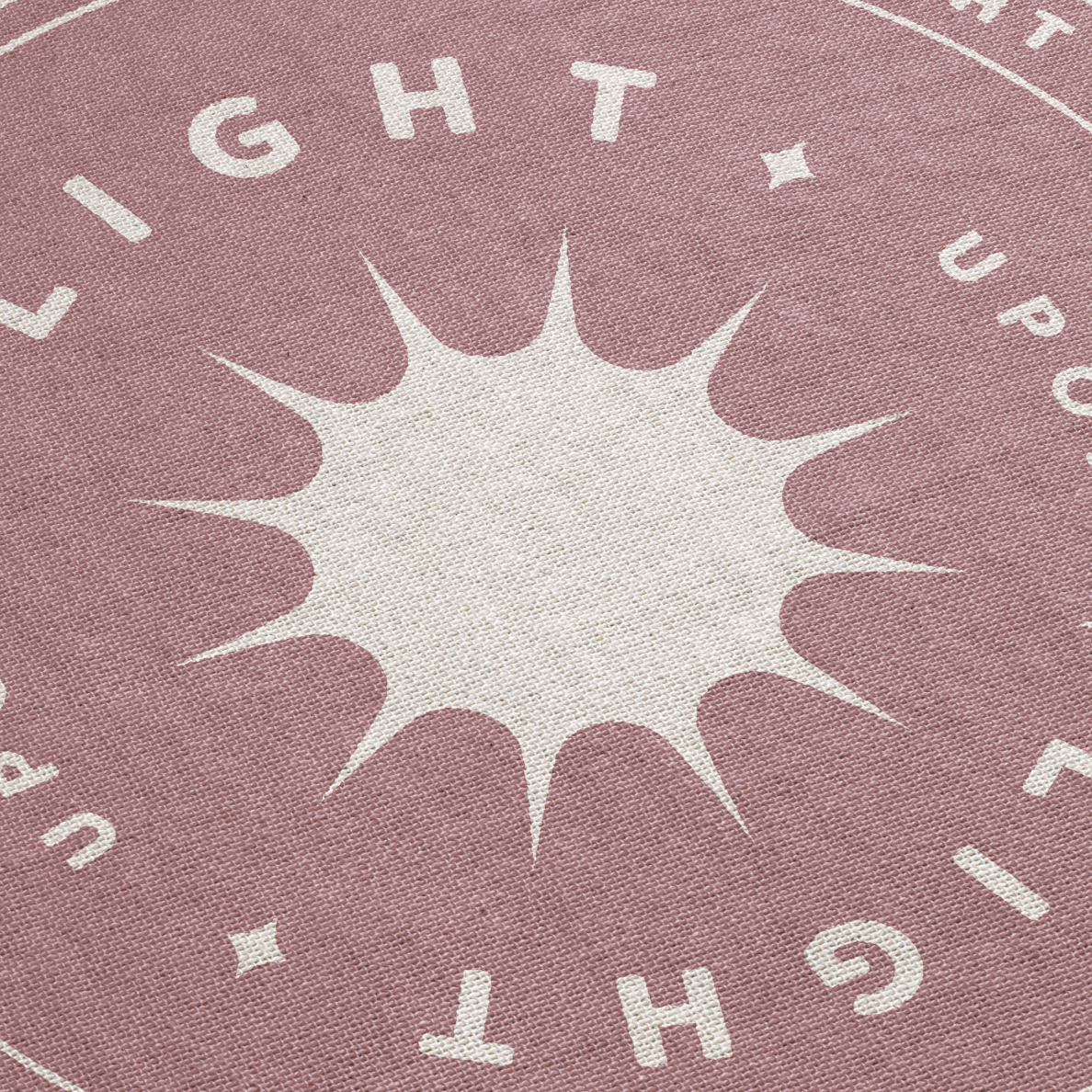 Textured fabric with star design and 'LIGHT UPON' text on a pink background