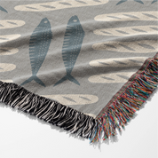 Woven Christian blanket featuring loaves and fishes pattern inspired by the miracle of Matthew 14; 100% cotton with fringe, a symbol of God’s provision and abundance.