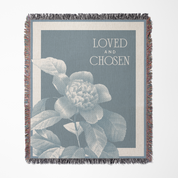 Throw blanket with floral design and 'Loved and Chosen' text on a blue background