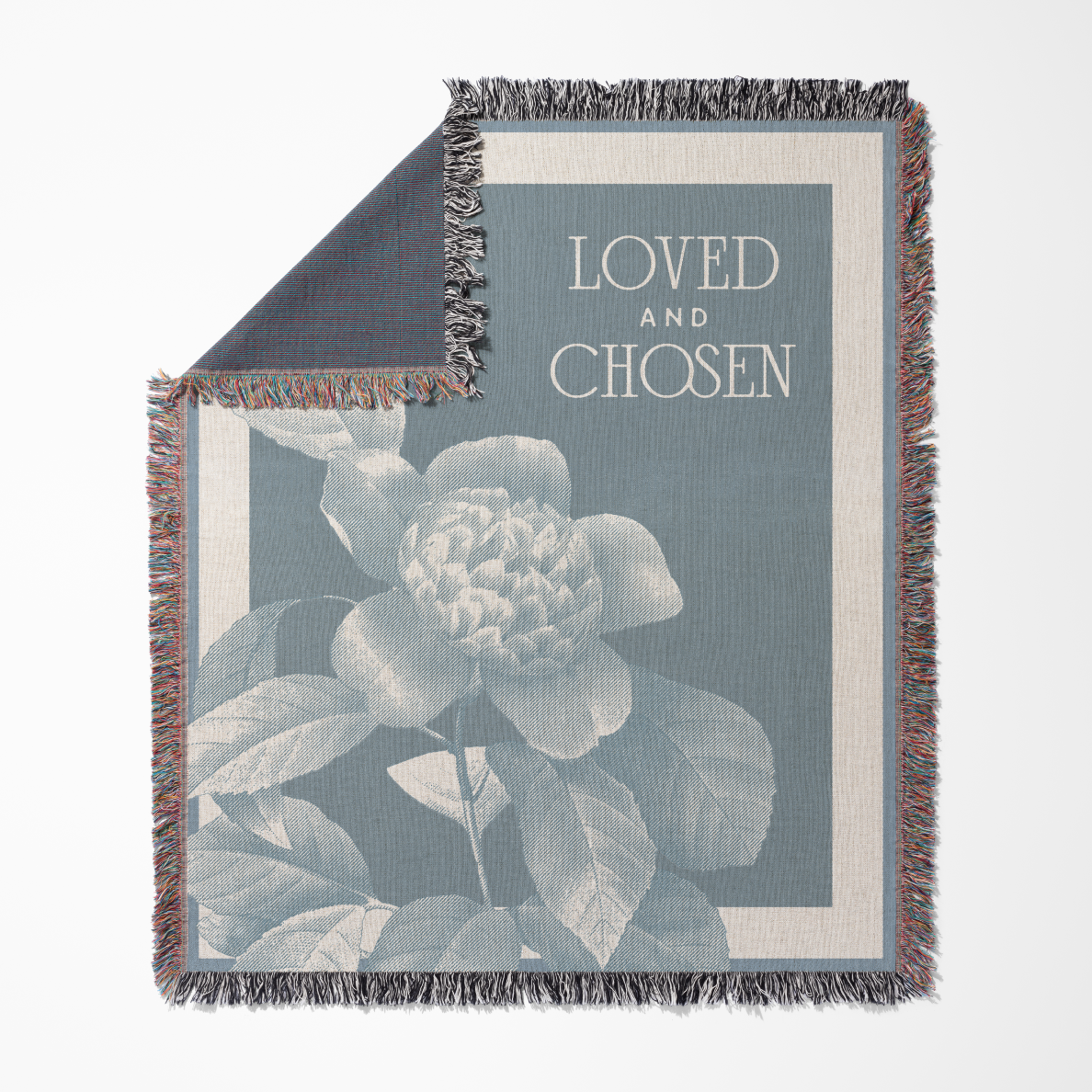 Woven blanket with floral design and 'Loved and Chosen' text on a white background
