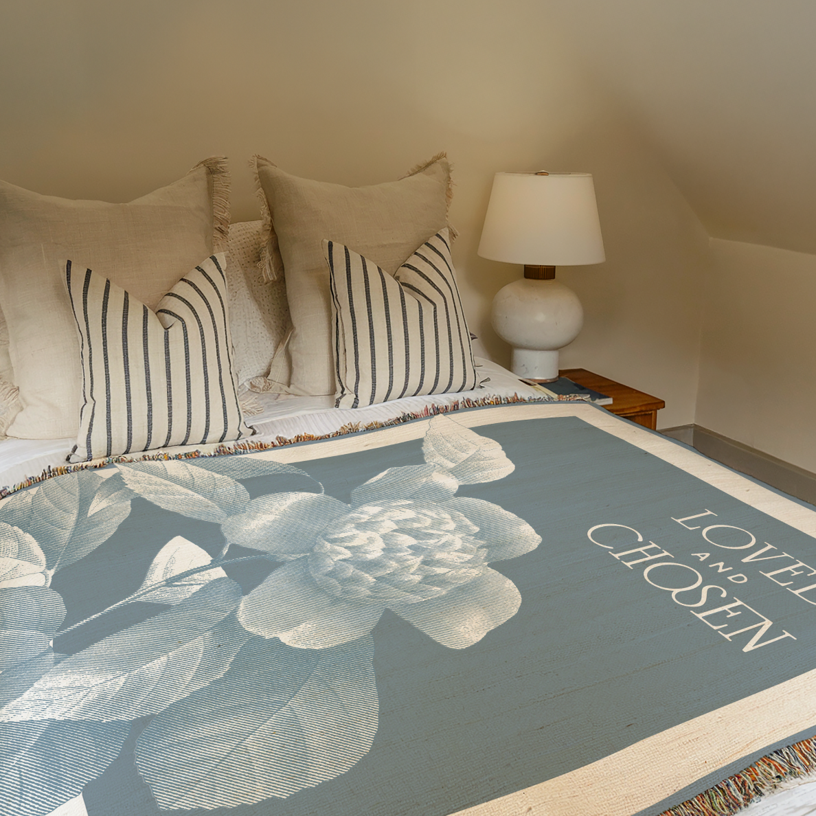 Bed with floral bedding and striped pillows, nightstand with lamp in a bedroom setting.